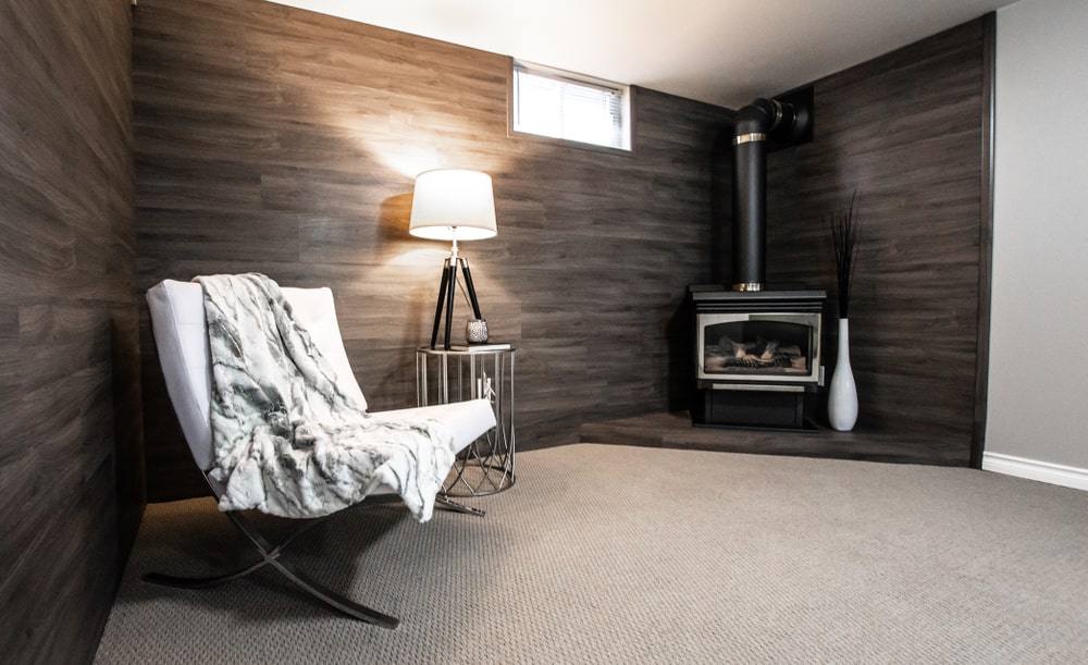 Basement Renovation Inspiration An accent wall surrounding a new wood stove in a basement.